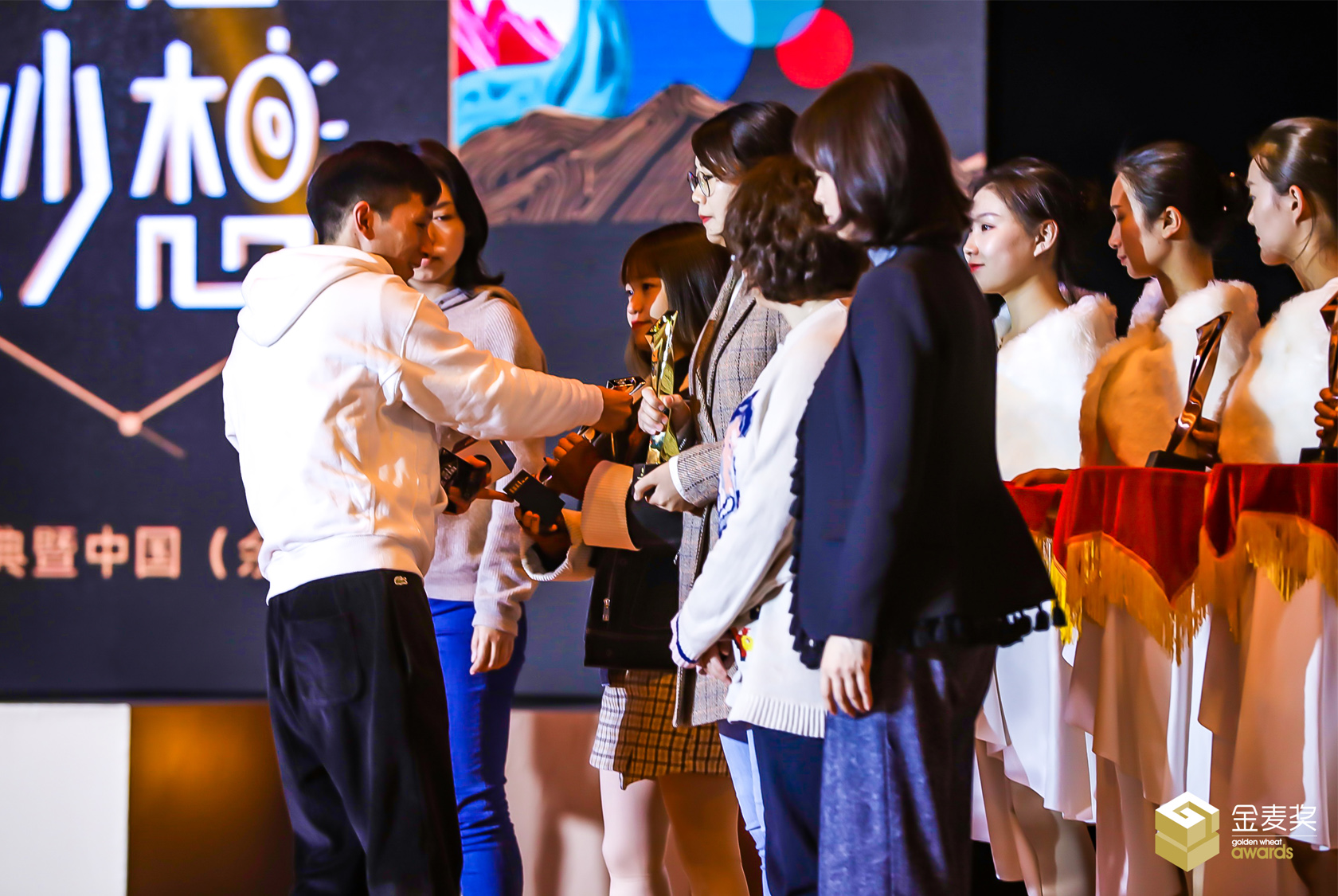 嘉賓和禮儀小姐上臺為金麥獎獲獎者頒發(fā)榮譽